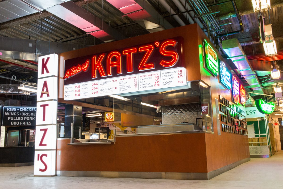 The A Taste of Katz’s counter at DeKalb Market Hall under the red neon Katz’s sign